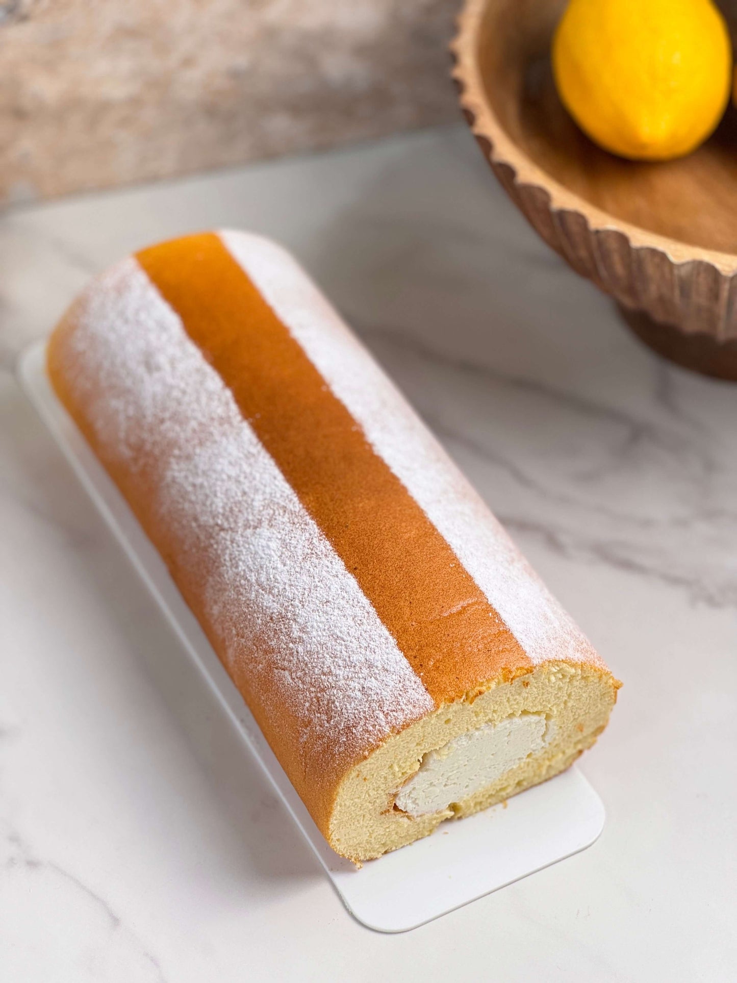 Japanese floating cloud cake roll featuring a fluffy sponge and delicate cream filling on a marble surface.