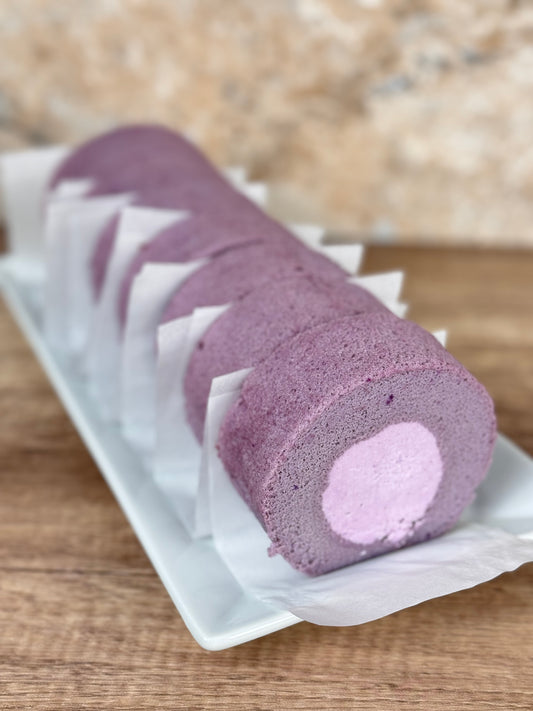 Ube Cake Roll with Taro Filling showcasing its vibrant purple slices on a white platter.