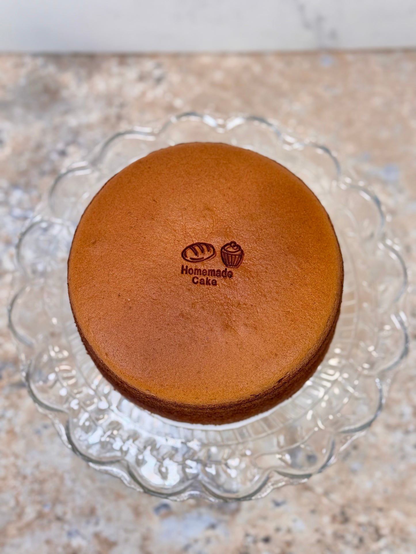 Chocolate Souffle Japanese cheesecake on a decorative glass cake stand.