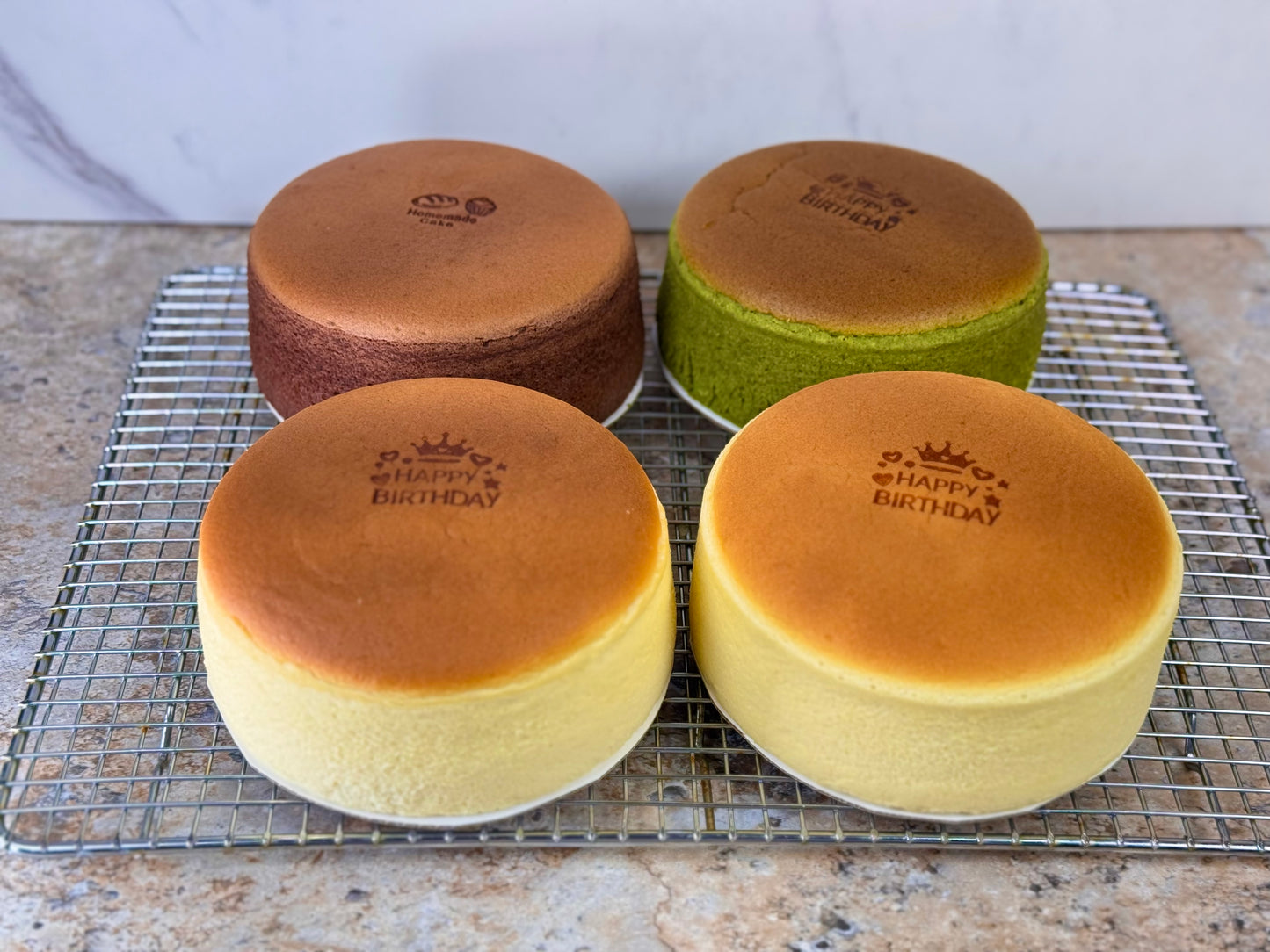 Matcha Japanese Souffle Cheesecake and assorted flavors on a cooling rack, showcasing an elegant dessert display.