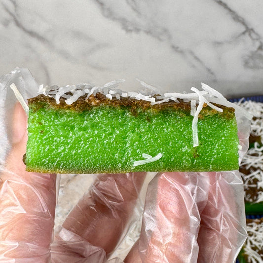 Close-up of vegan pandan coconut mochi bars, showcasing the vibrant green layer topped with shredded coconut.