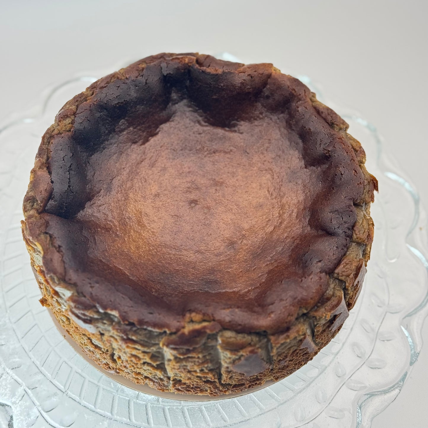 Creamy burnt Basque cheesecake infused with roasted hojicha tea, boasting a caramelized crust and a smooth, earthy-flavored center.