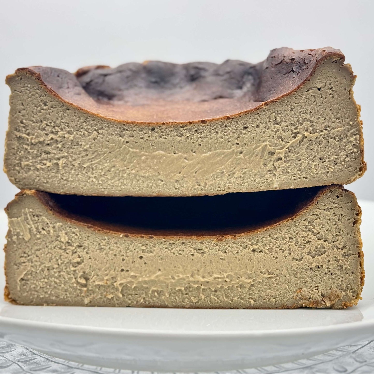 Creamy burnt Basque cheesecake infused with roasted hojicha tea, boasting a caramelized crust and a smooth, earthy-flavored center.