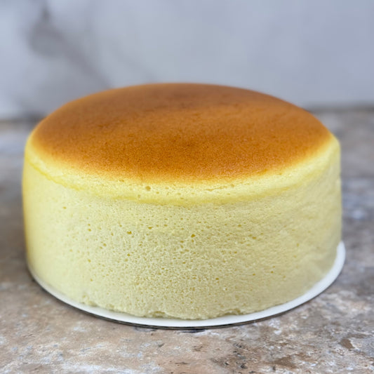 Japanese souffle cheesecake on a marble countertop showcasing its airy texture and golden-brown top.