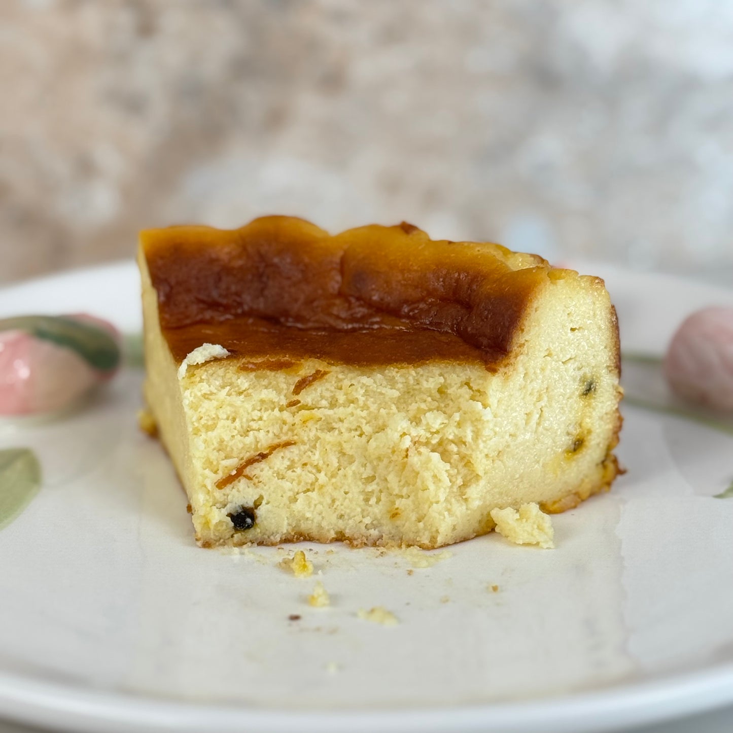 Slice of gluten free passion fruit burnt cheesecake on a white plate, showcasing its creamy center and caramelized top.