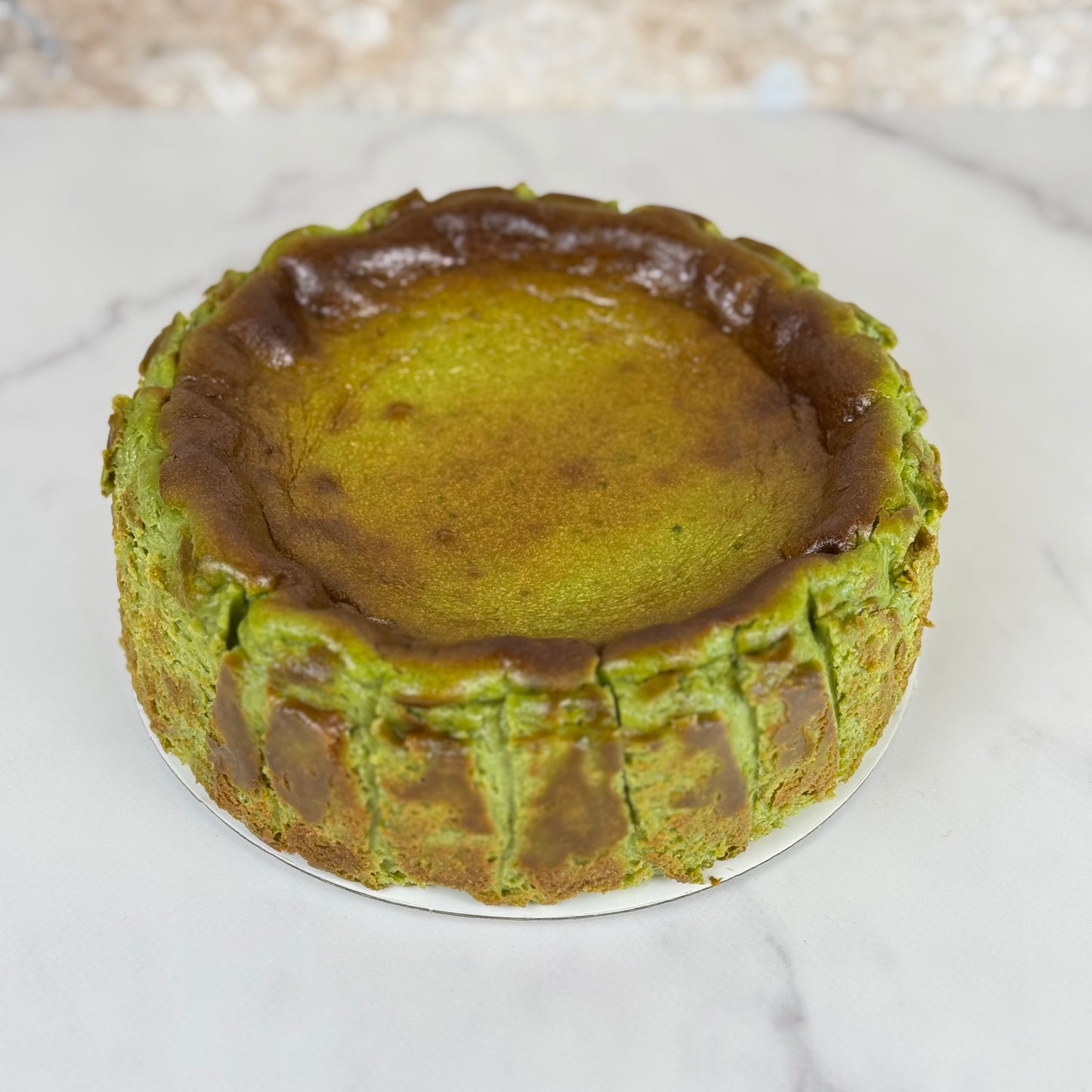 gluten-free matcha Burnt Basque cheesecake 6 Inch on a marble surface, showcasing its caramelized top.