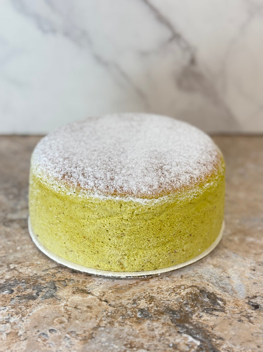 Pistachio Japanese souffle cheesecake Organic 6 Inch with a fluffy texture and powdered sugar on top.