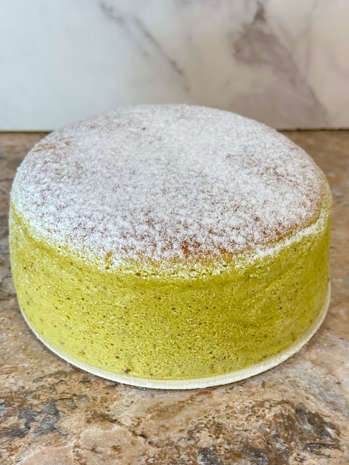 Pistachio Japanese souffle cheesecake, a fluffy dessert with a dusting of powdered sugar.