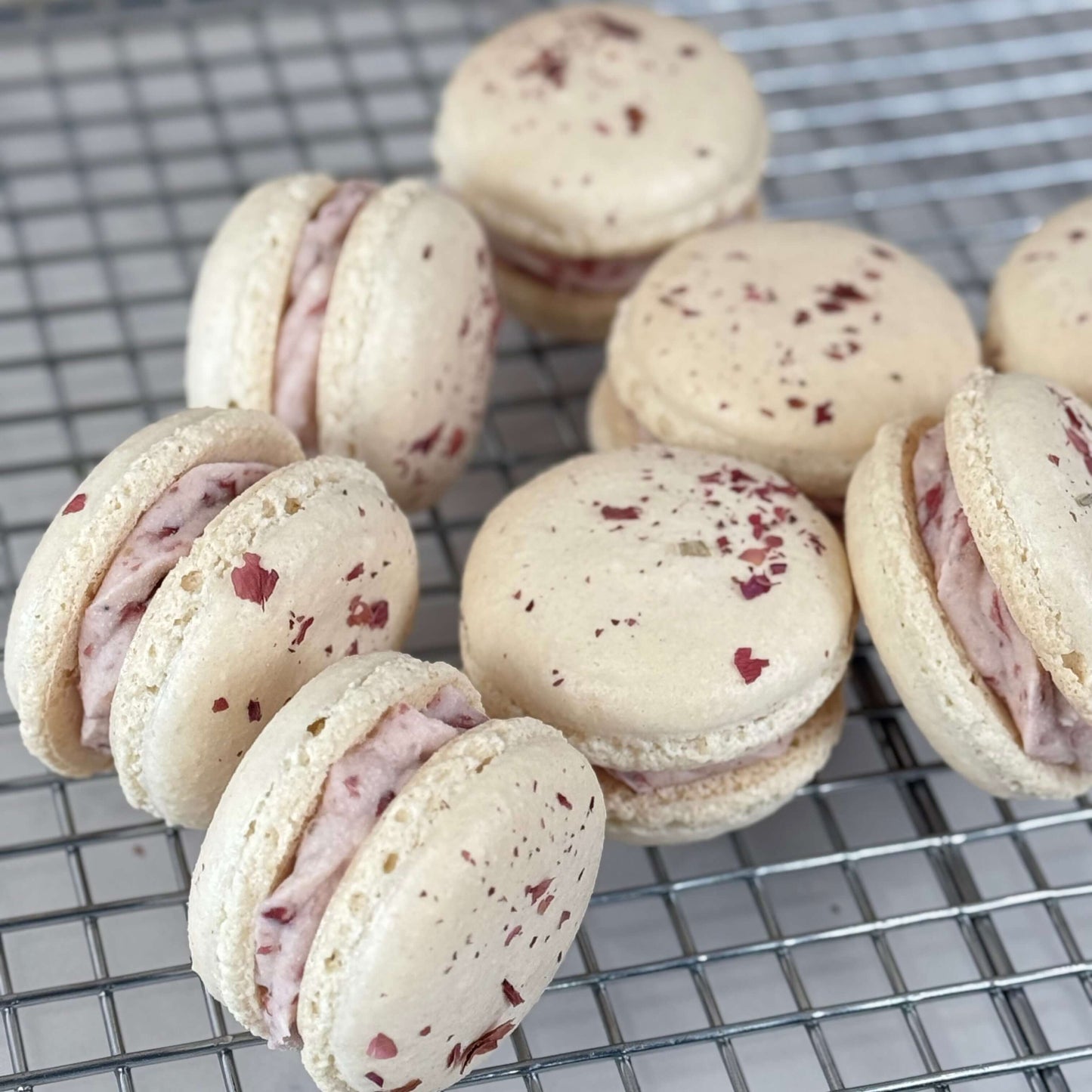 Organic Rose Macaron ingredients featuring 12 delicate, rose-infused confections on a cooling rack.