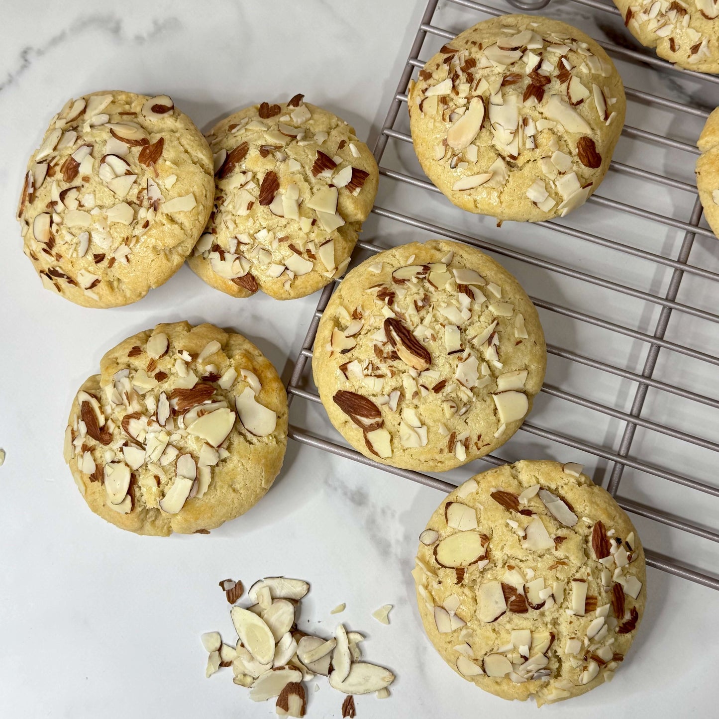 Almond Croissant Cookie With Frangipane, featuring a golden soft center and topped with sliced almonds.