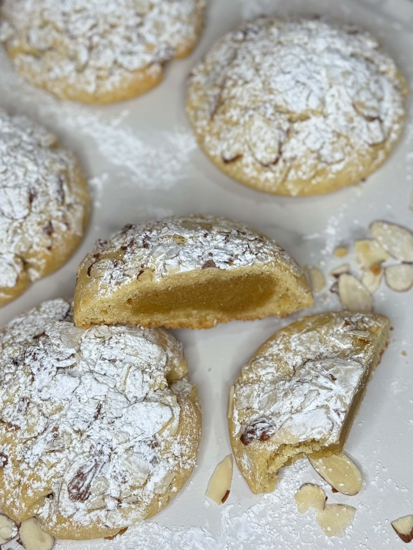 Almond croissant cookie with frangipane filling on a white plate, dusted with powdered sugar.