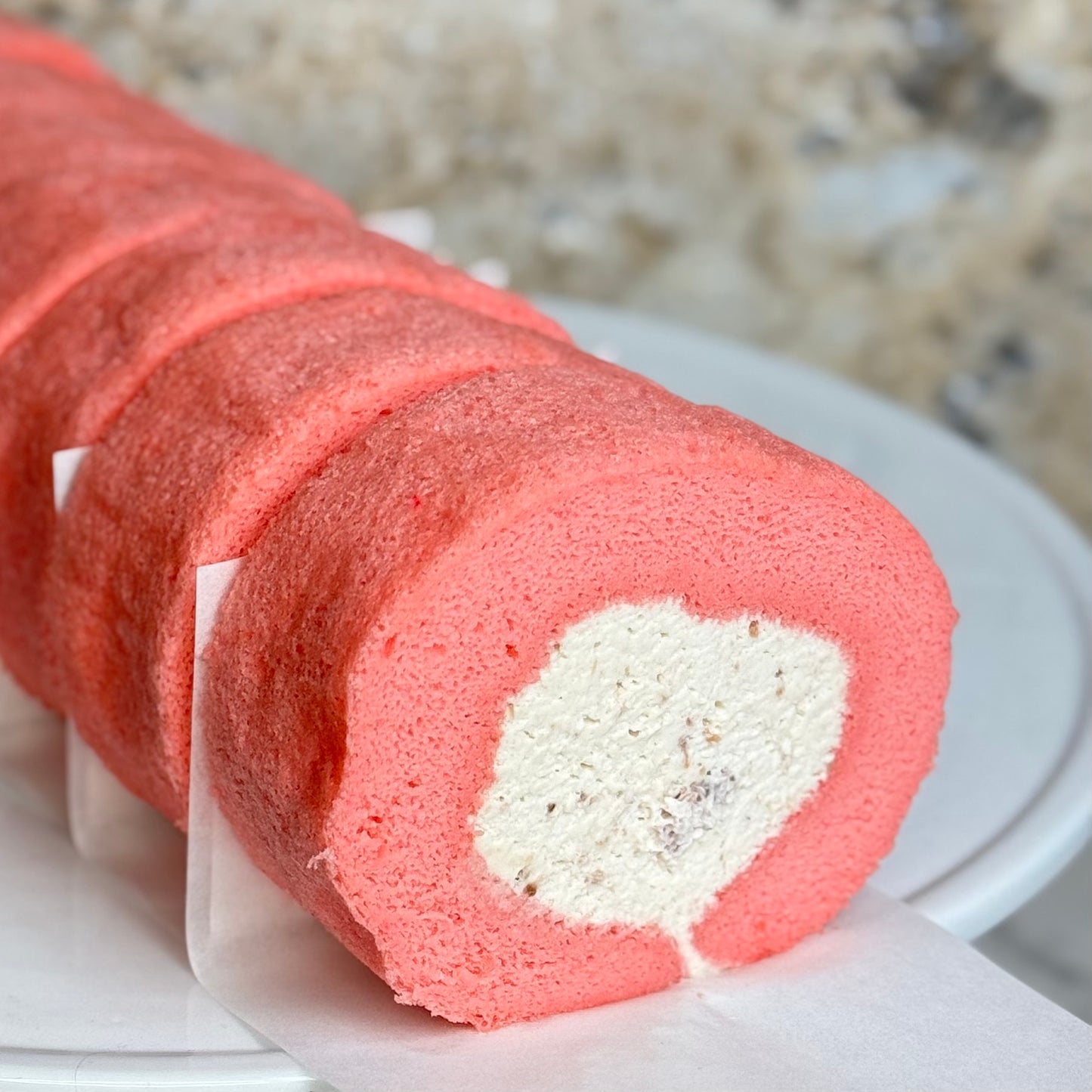 Rose Strawberry Cake Roll showcasing a fluffy pink sponge rolled with creamy filling and strawberry pieces.