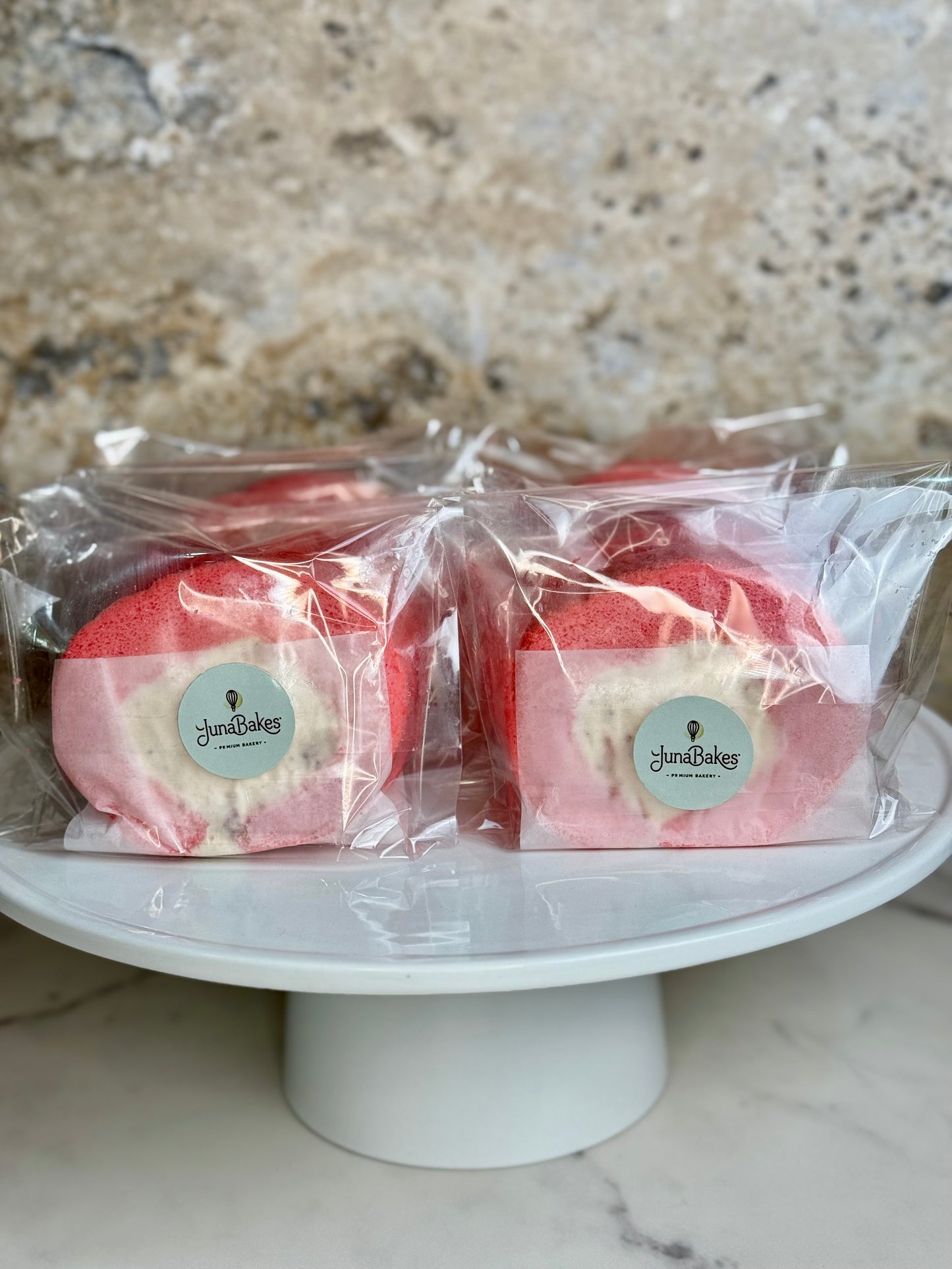 Rose Strawberry Cake Roll Organic packaged on a cake stand, featuring a delicate pink sponge and cream filling.