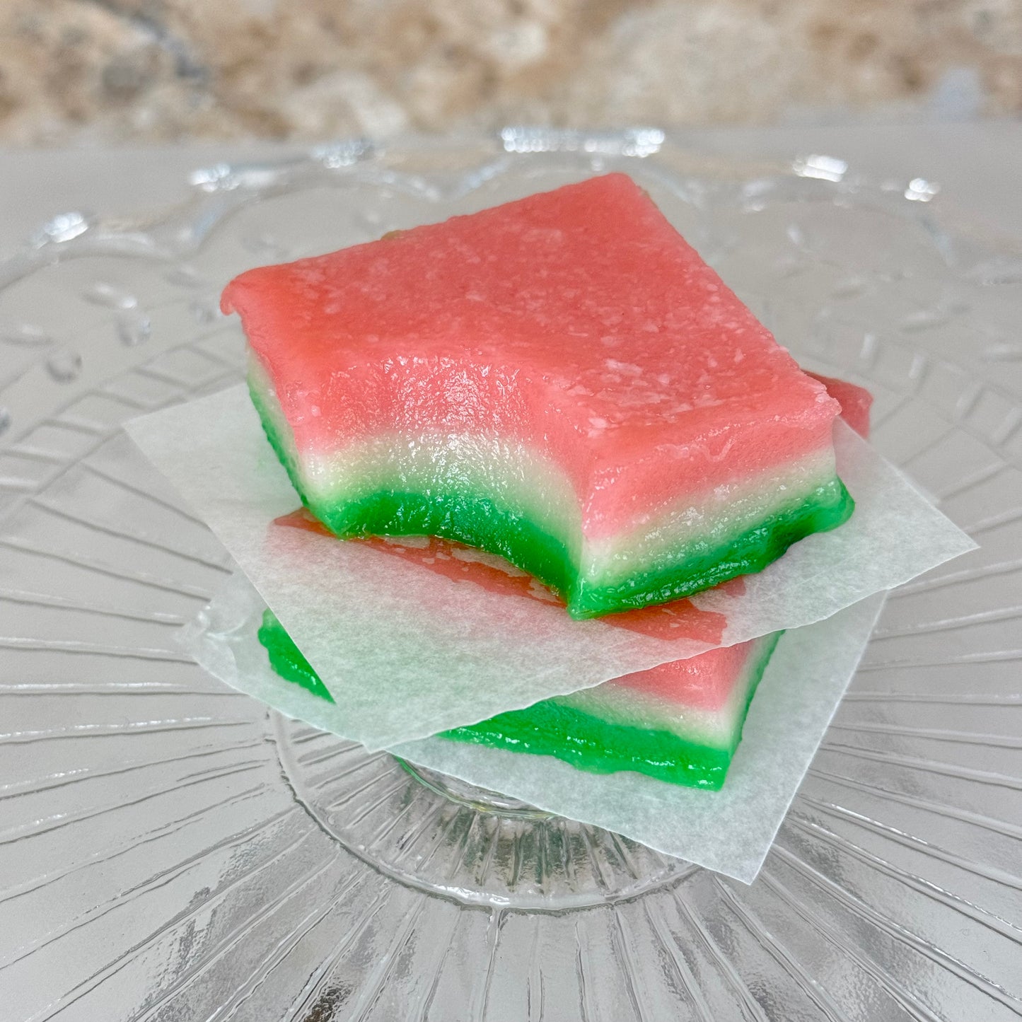 Vegan tri-color chi chi dango mochi bars showcasing vibrant layers of pink and green on a glass plate.