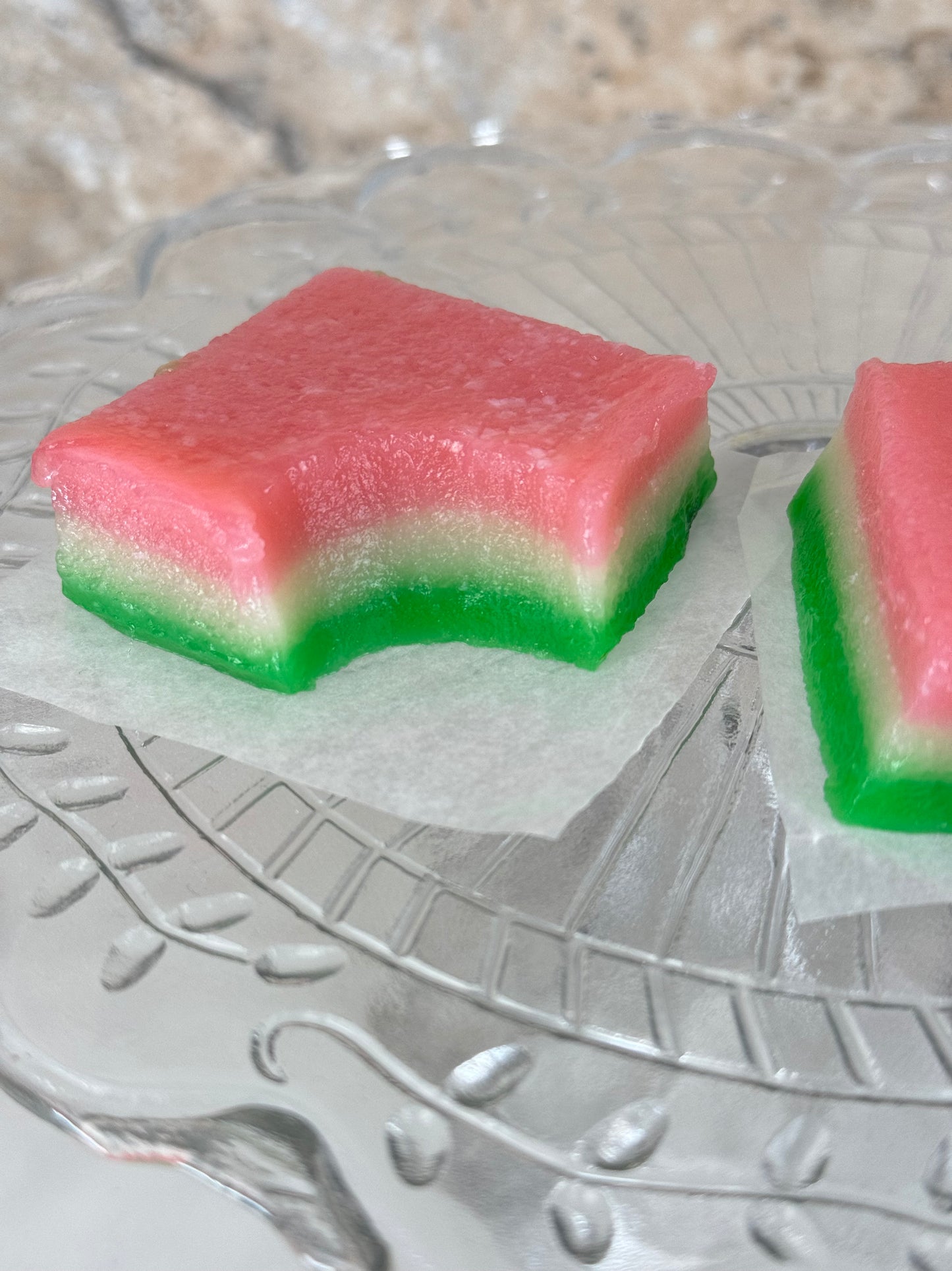 Vegan tri-color chi chi dango mochi bars on a decorative glass plate with pink, white, and green layers.