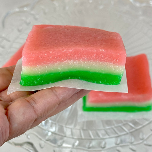 Vegan tri-color chi chi dango mochi bars showcasing pink, white, and green layers held in hand.
