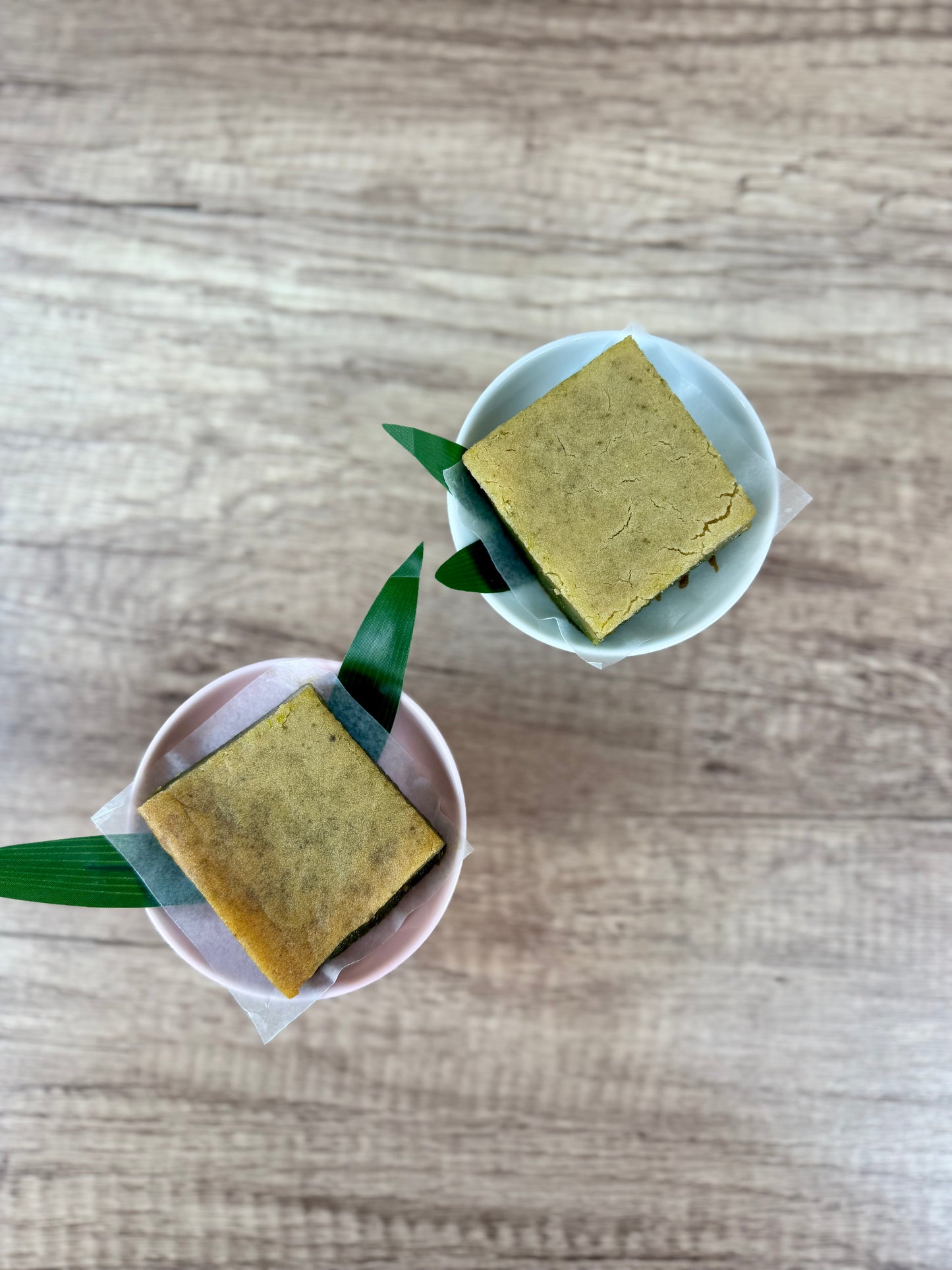 Vegan Jasmine Matcha Mochi Cake, organic dessert in two cups with green leaves, showcasing plant-based indulgence.