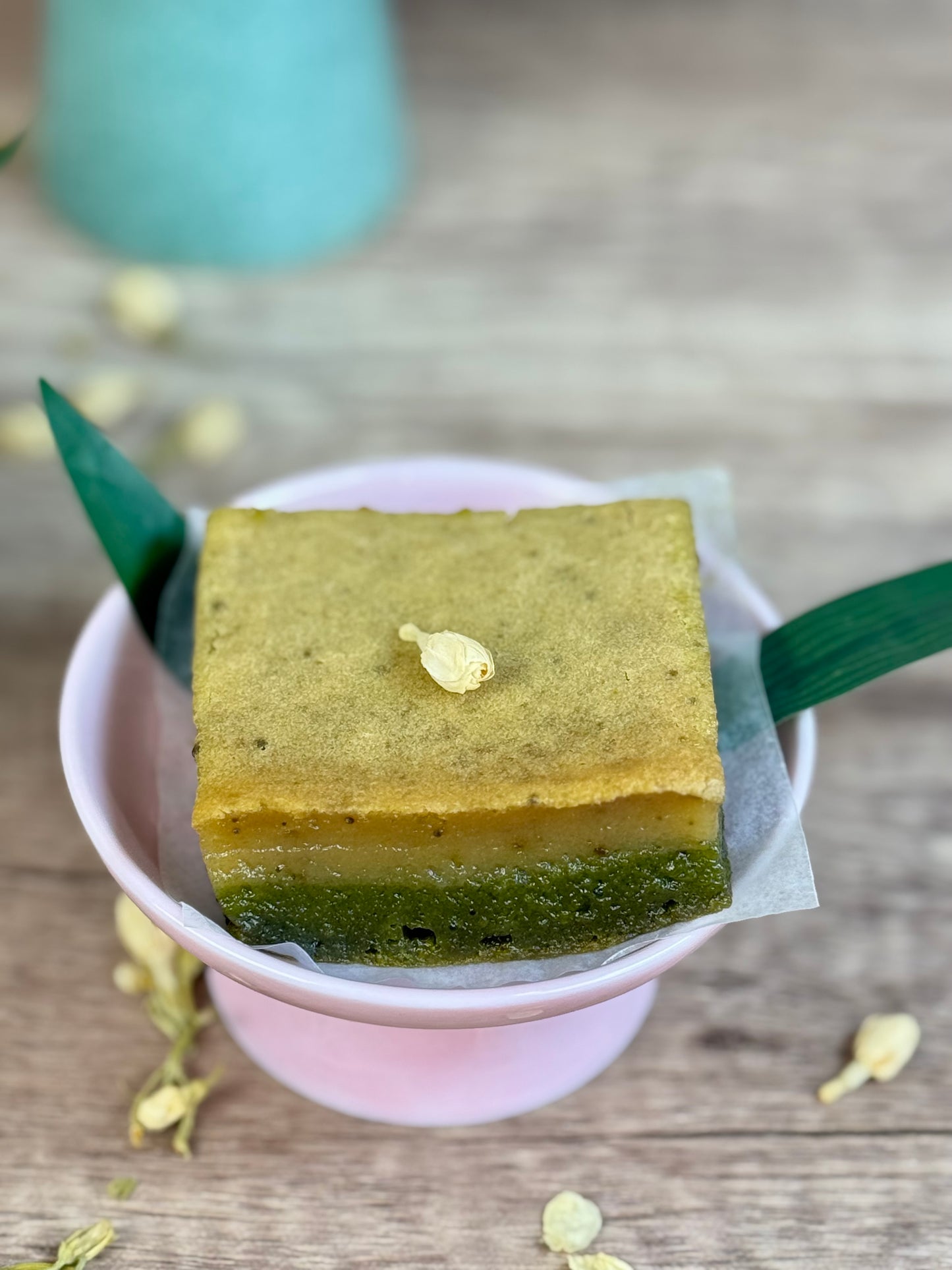 Vegan Jasmine Matcha Mochi Cake in a pink bowl, showcasing its vibrant layers and delicate presentation.
