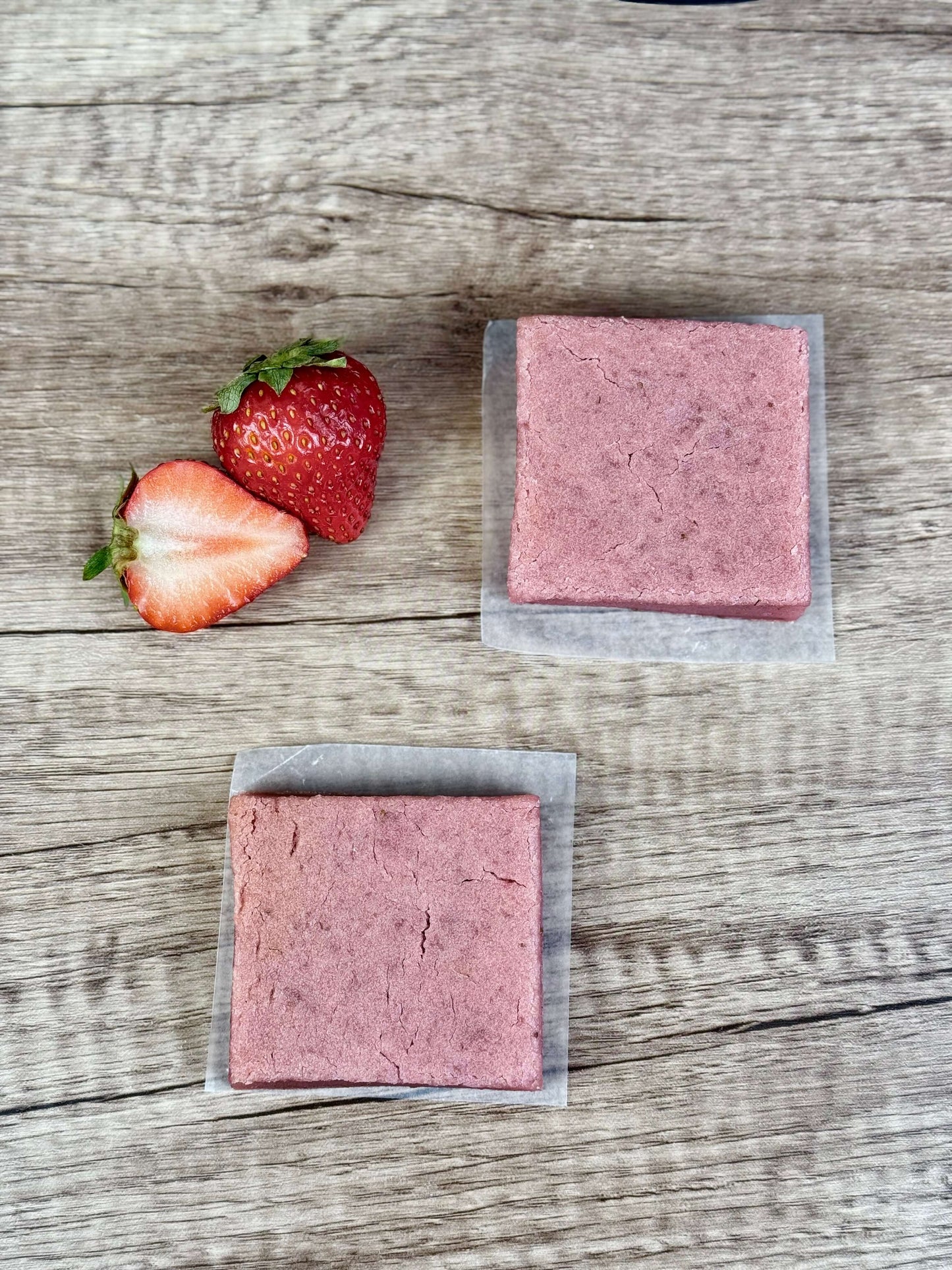 Vegan Strawberry Mochi Cake Bars displayed with fresh strawberries on a wooden surface, highlighting their chewy texture.