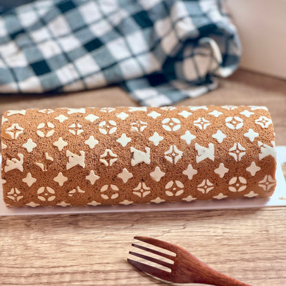 LV Chocolate Cake Roll showcasing intricate design and luxurious texture on a wooden surface.
