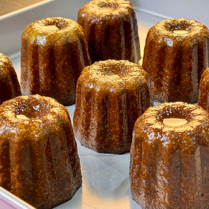 Traditional French cannelés with a caramelized crust and tender vanilla-rum custard center, baked to golden perfection in copper molds.