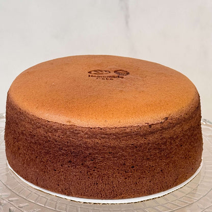 Chocolate Souffle Japanese cheesecake 6 Inch on a glass cake stand with a smooth top.