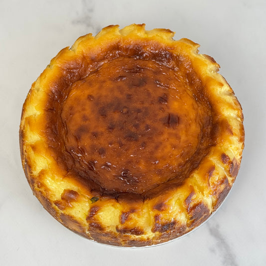 Creamy burnt Basque cheesecake infused with tangy passion fruit, featuring a caramelized top and a silky, custard-like center with tropical flair.