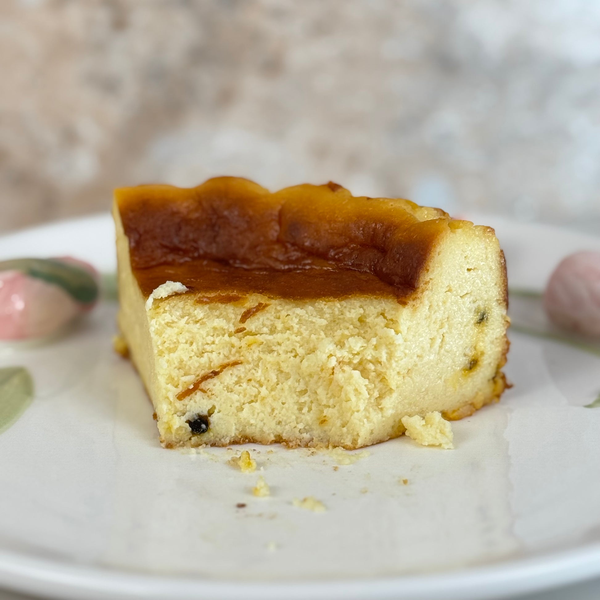 Slice of gluten free passion fruit burnt cheesecake on a white plate, showcasing its creamy center and caramelized top.