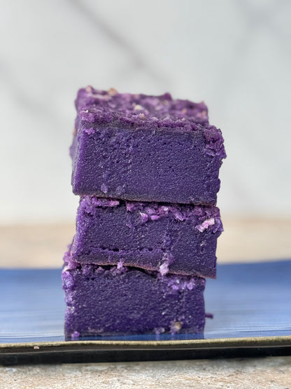 Stack of vibrant purple Ube Coconut Butter Mochi Cake Bars, showcasing their chewy texture and rich color.