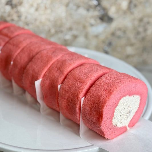 Rose Strawberry Cake Roll showcasing a fluffy pink sponge filled with creamy rose and strawberry filling.