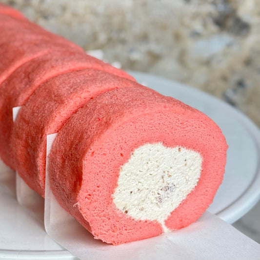 Rose Strawberry Cake Roll showcasing a fluffy pink sponge rolled with creamy filling and strawberry pieces.